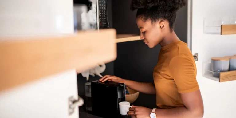 Woman brewing coffee with an automatic espresso machine