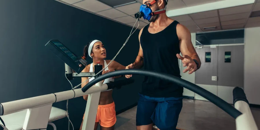 Woman giving instruction to male runner on treadmill in laboratory