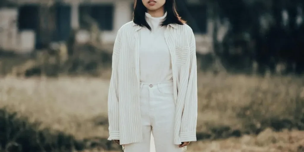 Woman in white clothes posing in a Paris park during the day