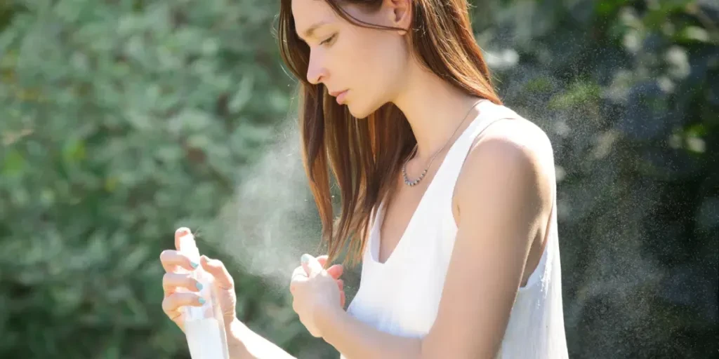 Woman refreshing with thermal water against summer heatwave