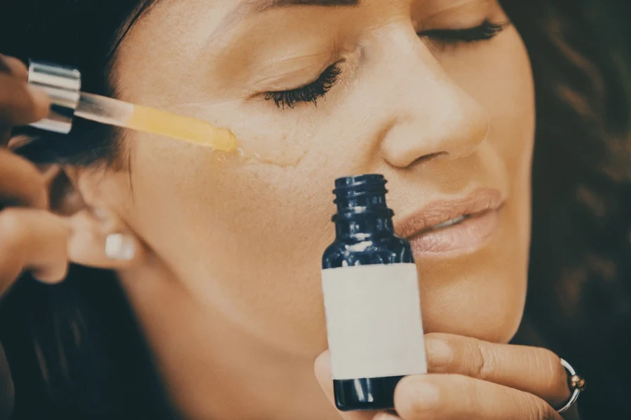 Woman using retinol oil on corners of eyes