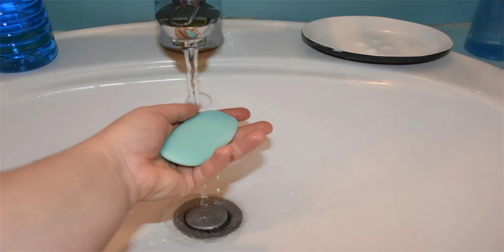 Woman washing hands with soap in bathroom