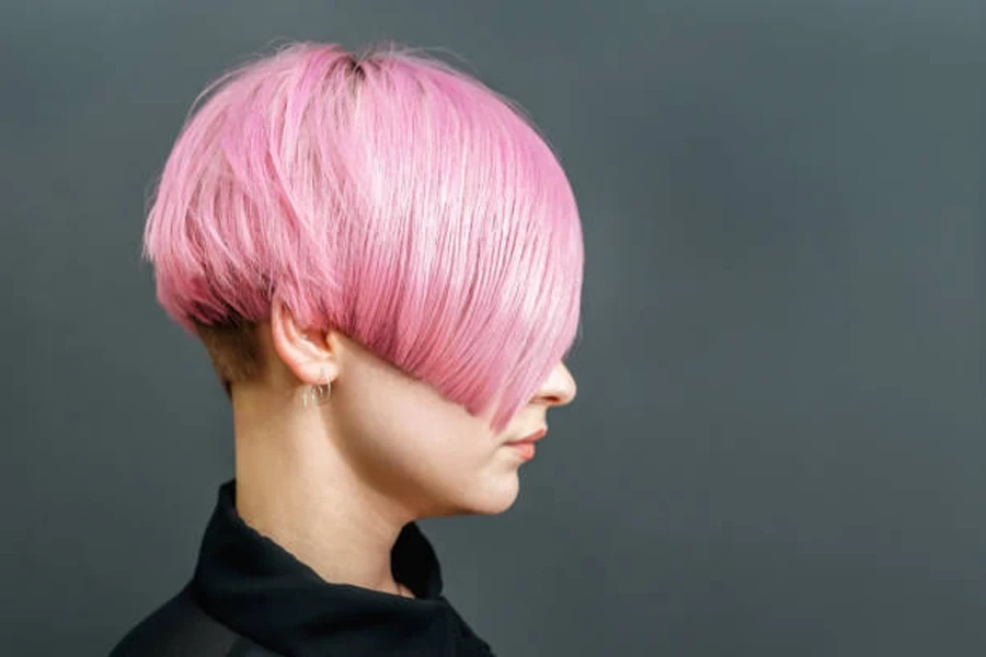 Woman with bright pink hair worn in Karen haircut