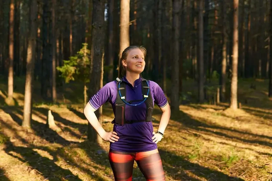 Young female runner jogging in pine forest