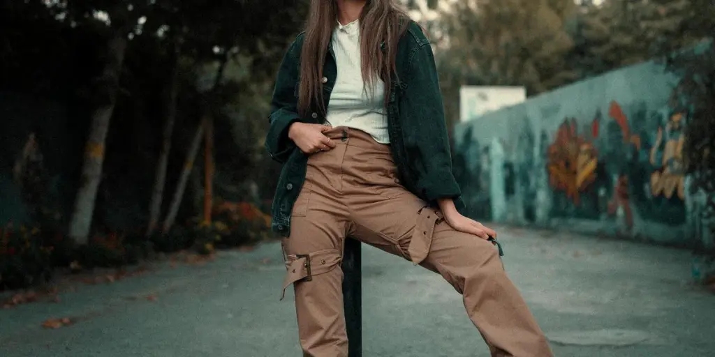 Young woman leaning against a pole with a boombox, showcasing a street fashion look