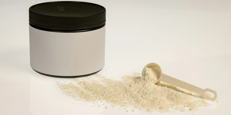 a jar of powder next to a scoop of powder