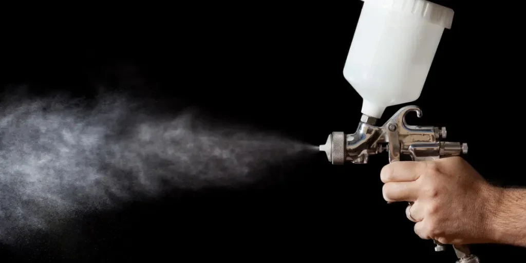 a spray paint gun with black background