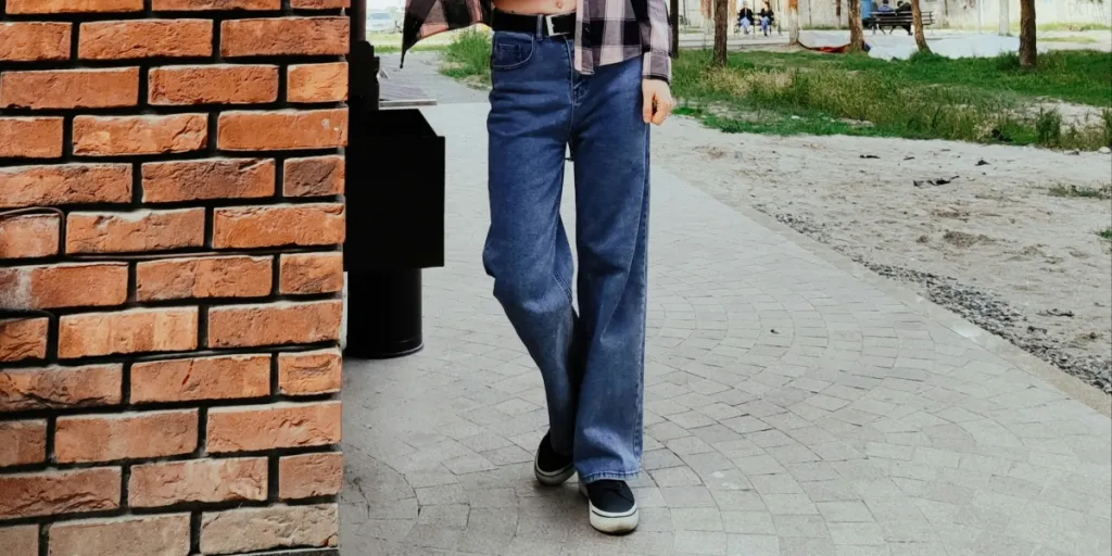 a woman standing next to a brick wall