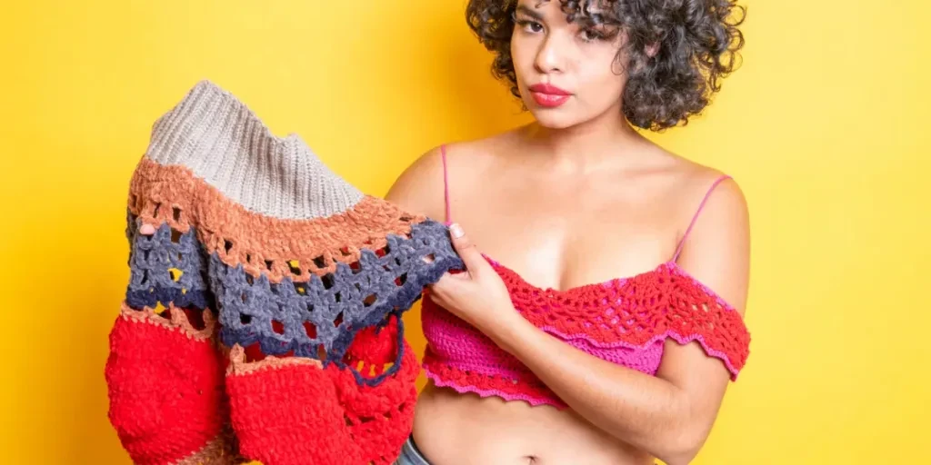 beautiful young mexican woman showing handmade clothes woven with yarn