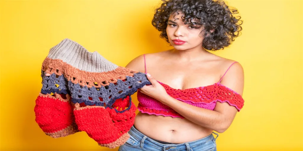 beautiful young mexican woman showing handmade clothes woven with yarn