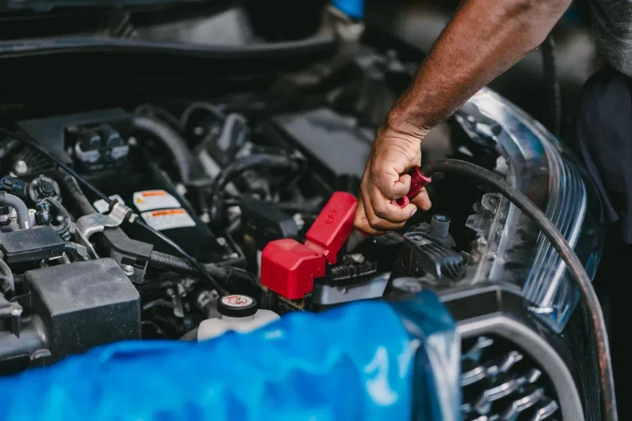 Car mechanic clamping car battery terminal