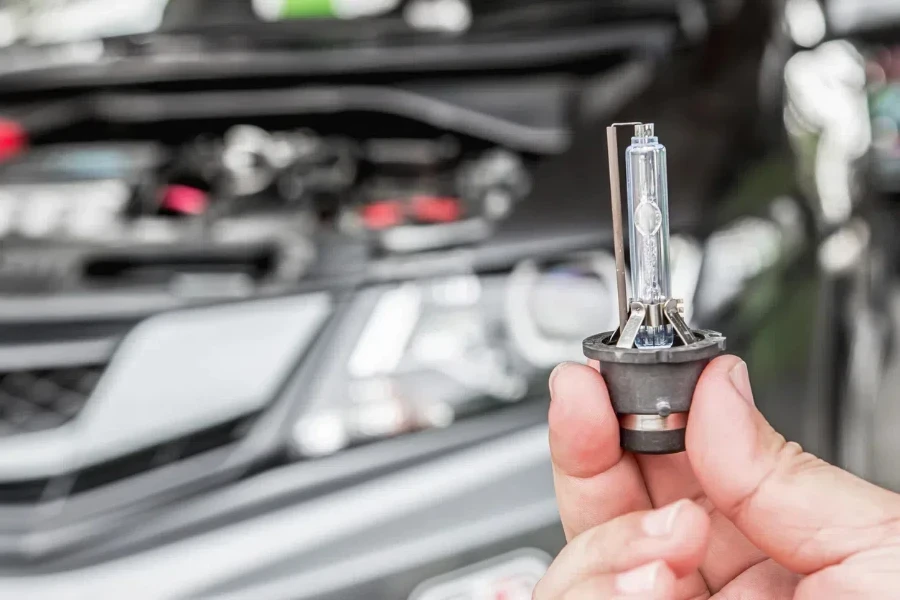 Close up car headlights xenon lighting equipment in man’s hand