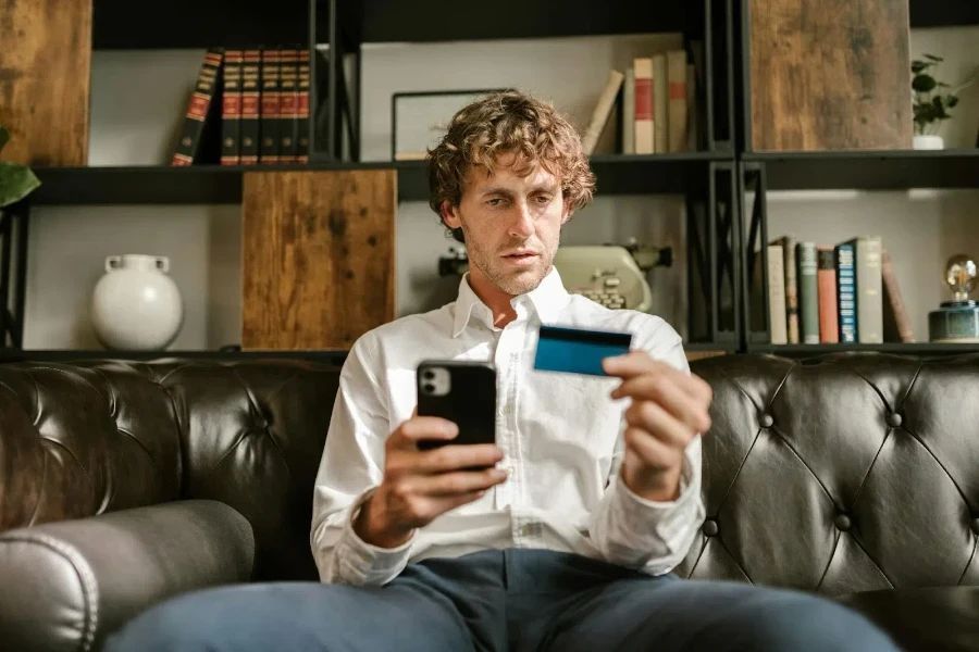 Man holding a card and cellphone