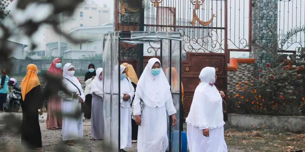 people in white robe standing in front of white concrete building during daytime