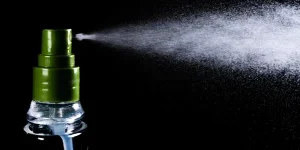perfume bottle and perfume droplets on black background