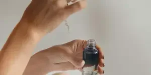 person holding black glass bottle
