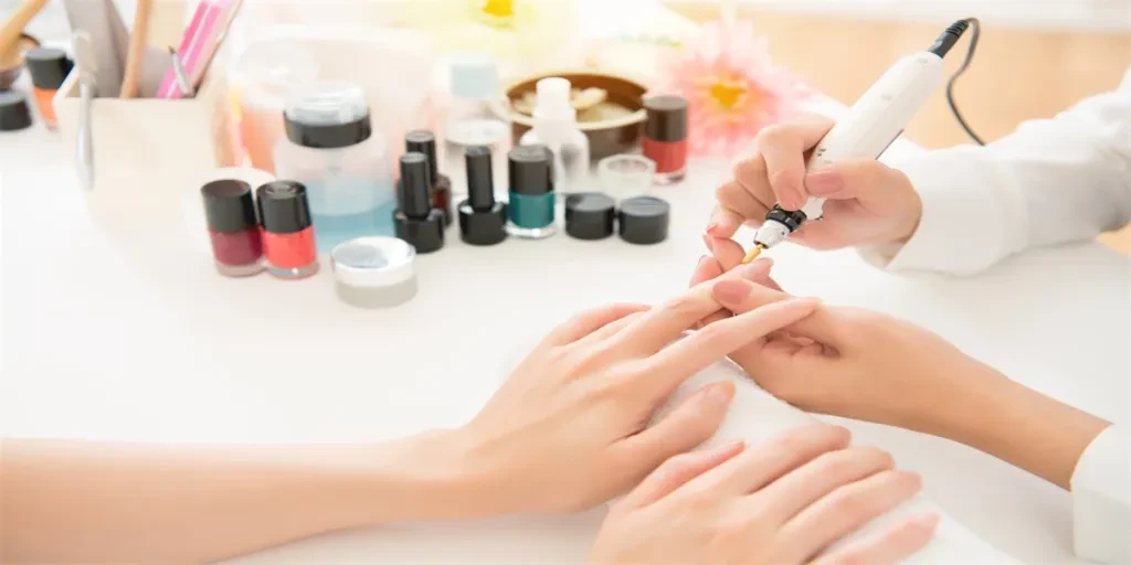 salon manicurist using electric nail drill