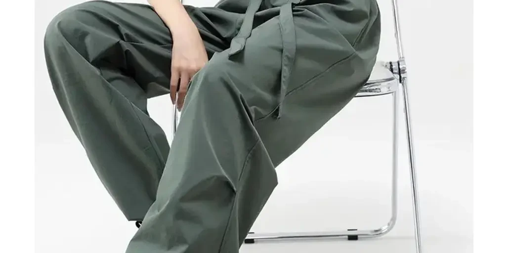 the woman wearing the green parachute pant sitting on the chair