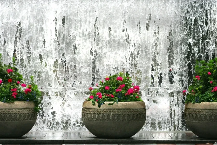 three brown clay decorative pots with pink flowers