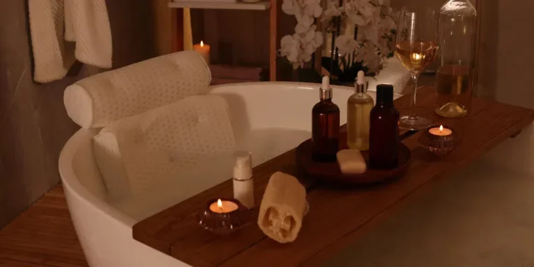 ub with soft bath pillow, toiletries and wine indoors