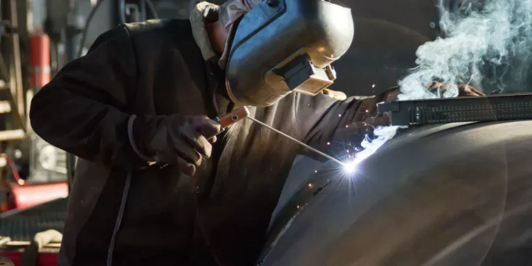 welder brews manual arc welding a workpiece of large diameter pipe