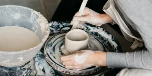 Frau töpfert im Atelier mit gemischtem Ton