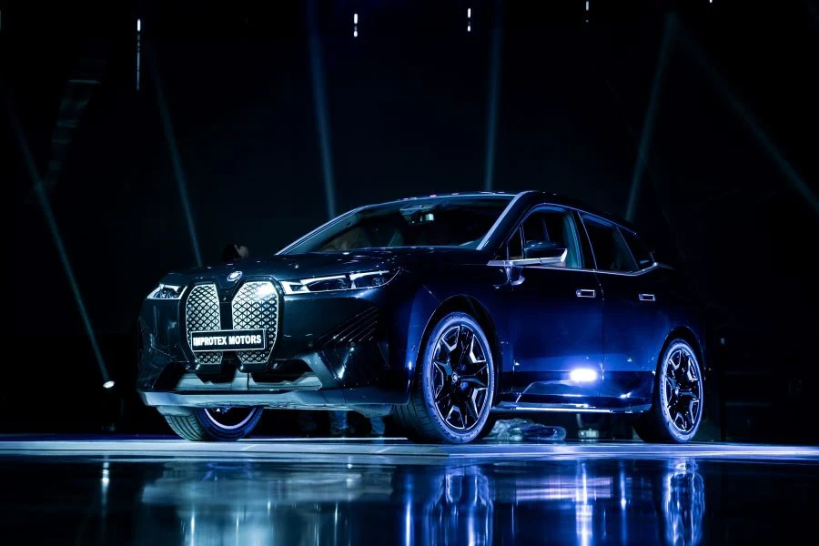 A BMW iX on display in a dark room