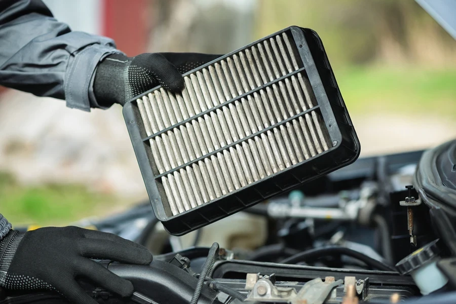 A person holding a rigid frame engine air filter