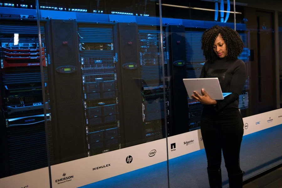 A software engineering standing beside server racks