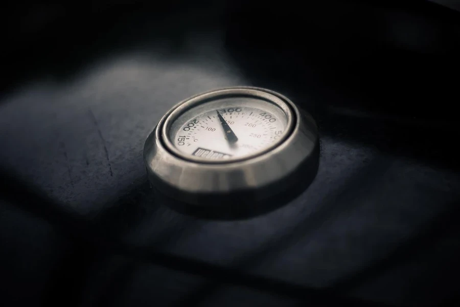 Analog oven thermometer on a black background