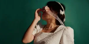 Artistic Portrait of Woman in White Dress with Floral Blindfold