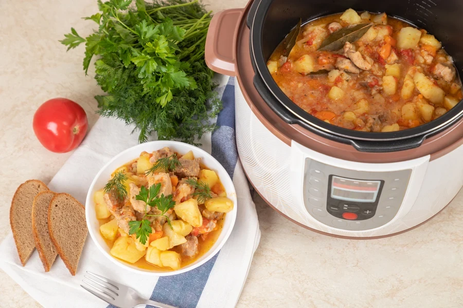 Beef stew in a bowl beside a crockpot