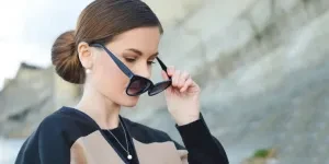 Elegantly dressed woman holding sunglasses