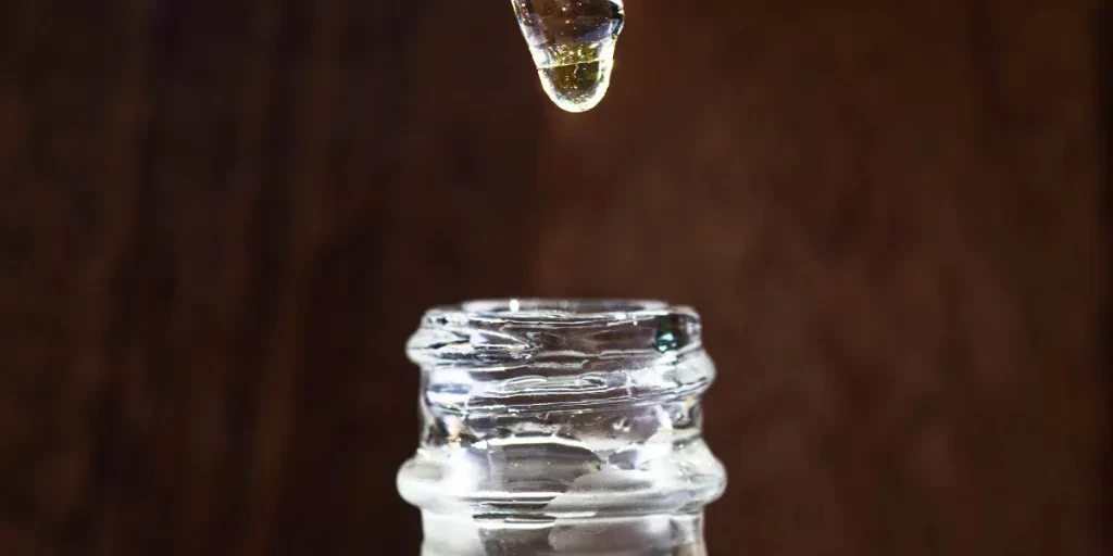 Glass Jar Of Face Oil And A Dropper Above It