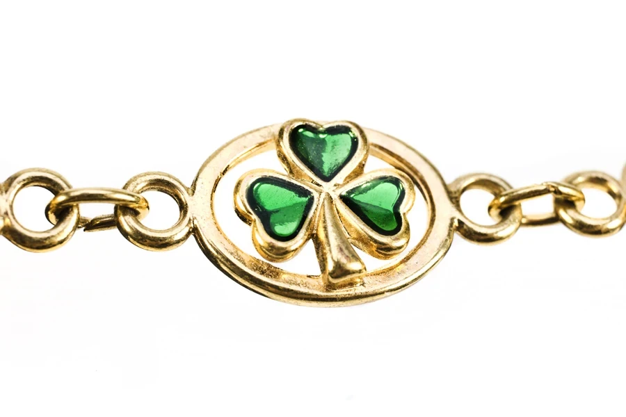 Gold bracelet with emerald clover design in center