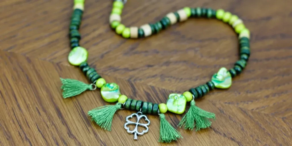 Green beaded necklace with silver clover charm in center