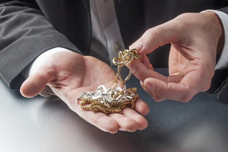 Man holding a selection of jewelry in hands