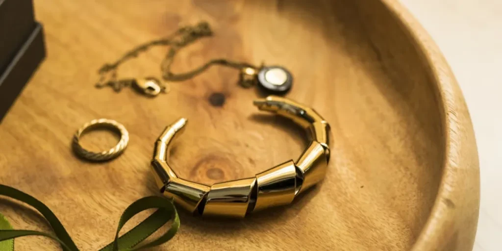 Ornate chunky gold bracelet next to other pieces of jewelry