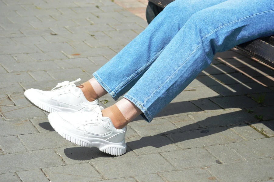 Person sitting down in cropped straight cut jeans