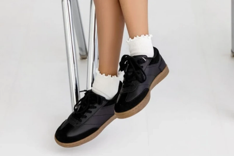 Schoolgirl wearing white cotton ruffle socks with black shoes