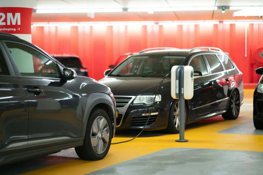 Two black cars next to a charging station