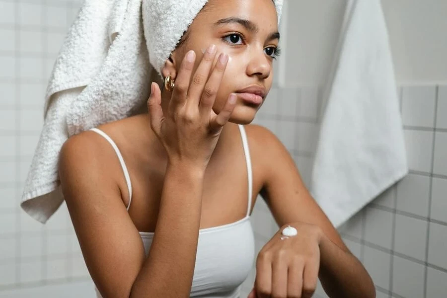 Woman applying cream on her face