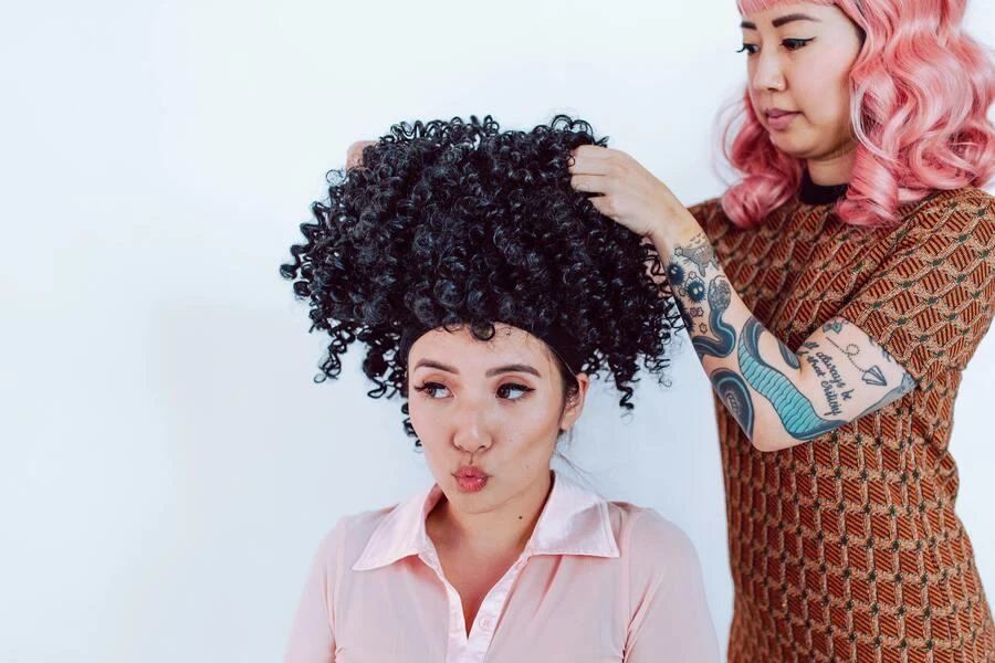 Woman fitting a curly hairpiece