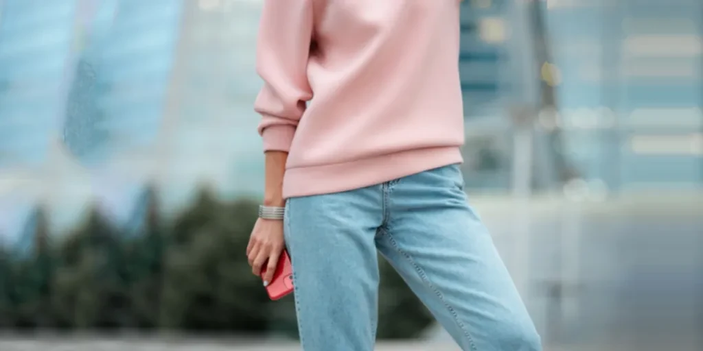 Woman in a pink sweat-shirt and straight-leg jeans