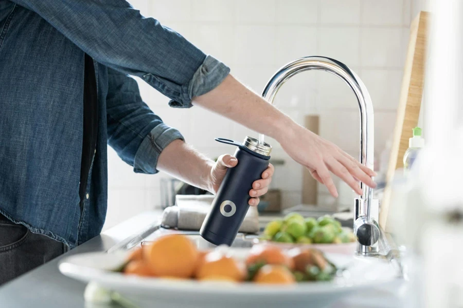 Woman pouring water into a water bottle