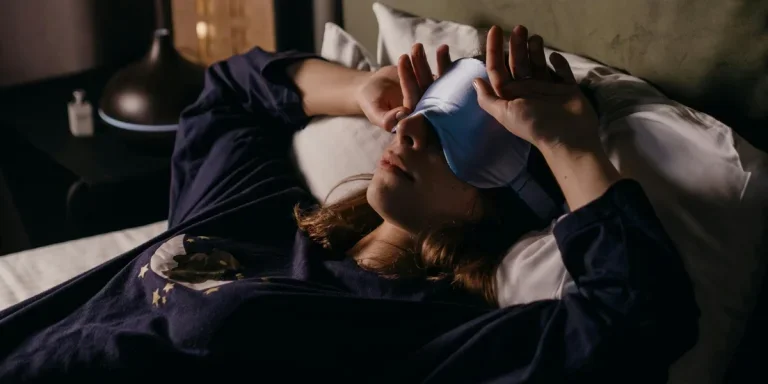Woman wearing eye mask and lying in bed