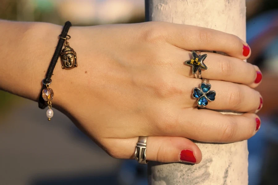 Woman wearing four-leaf clover ring and collection of charms