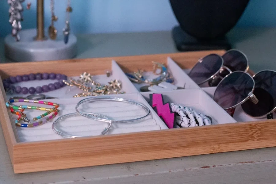 A wooden jewelry tray on a table