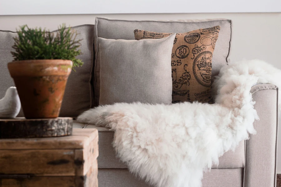 sofa with soft pillows and faux fur blanket