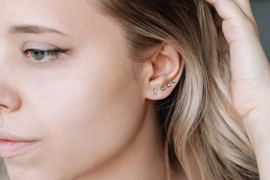 Woman wearing wearing four flat back earrings